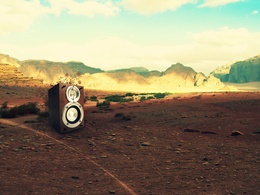 3d обои В безлюдной пустыне стоит  одиноко колонка с динамиками, из которой музыкальные звуки выходят в виде ажурных  цветов  техника