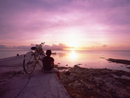 3d обои Девочка смотрит на морской закат с потрескавшегося бетонного пирса, спешившись с велосипеда, который стоит рядом  солнце