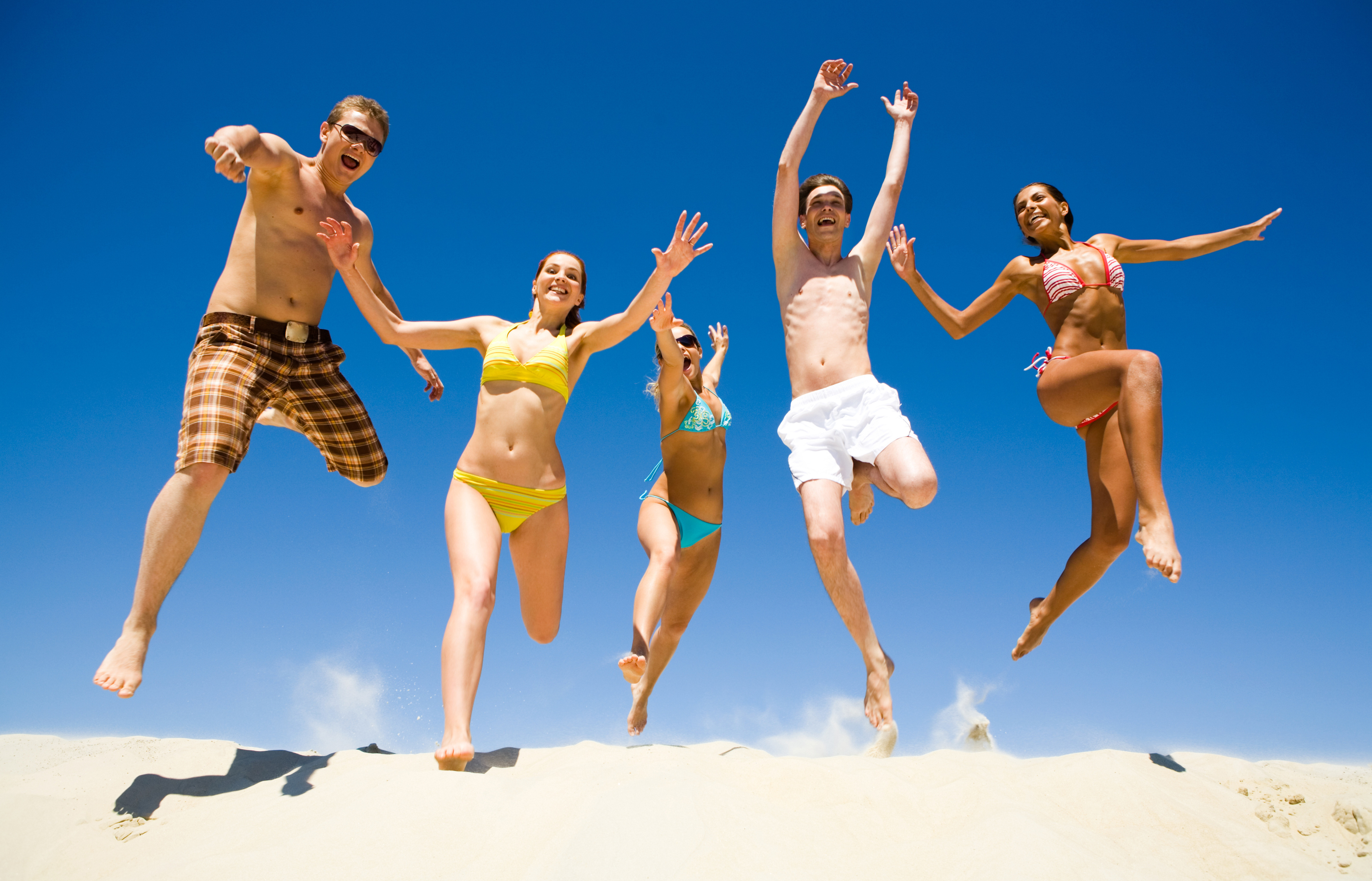 3d обои Мужчины в плавках и девушки в купальниках весело прыгают по песку пляжа  эмоциональные # 89895