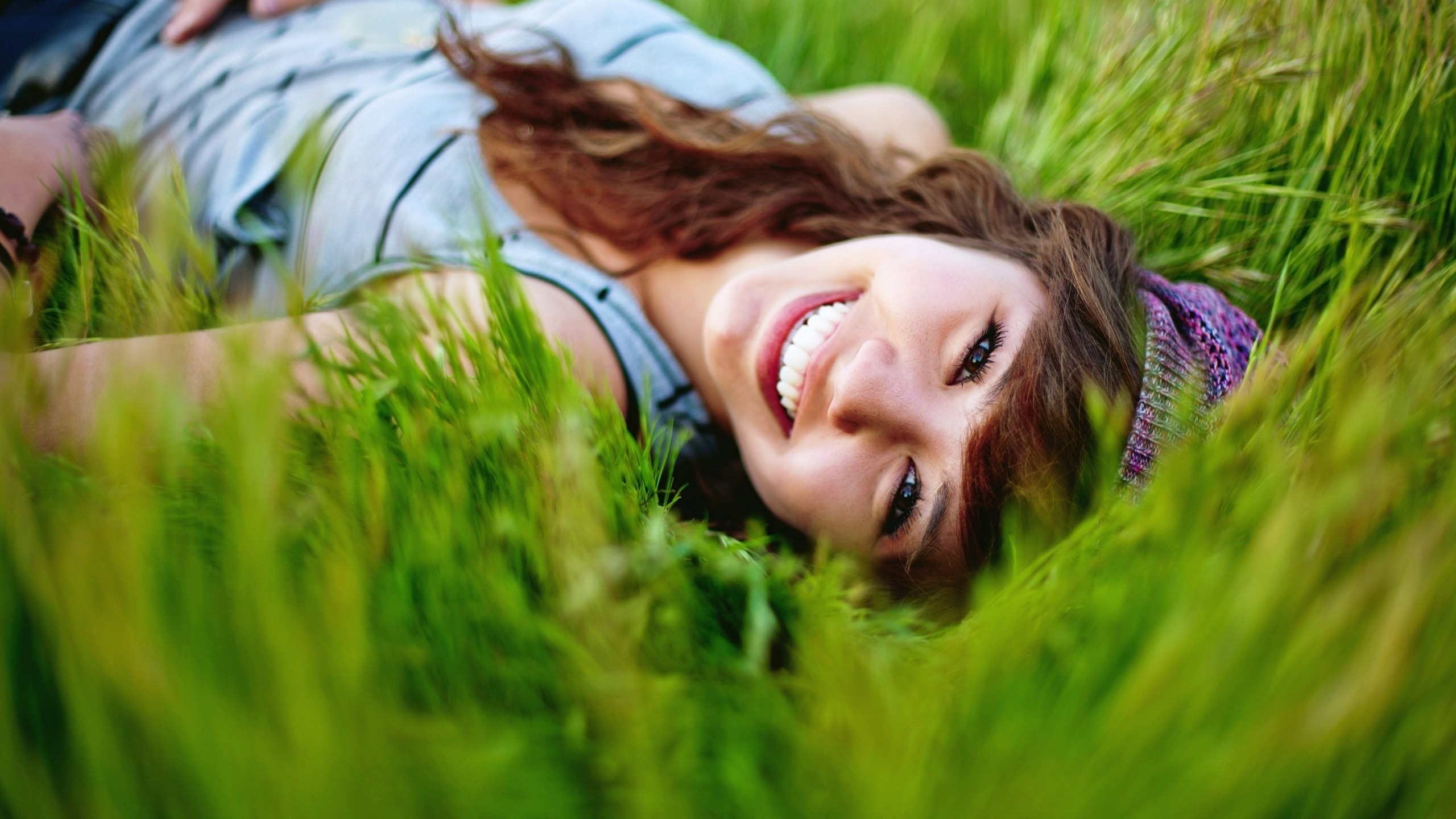 3d обои Улыбающаяся девушка лежит в зеленой траве  2560х1440 # 15340
