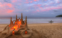 3d обои Замок из песка со свечками и серфер на закате  мужчины